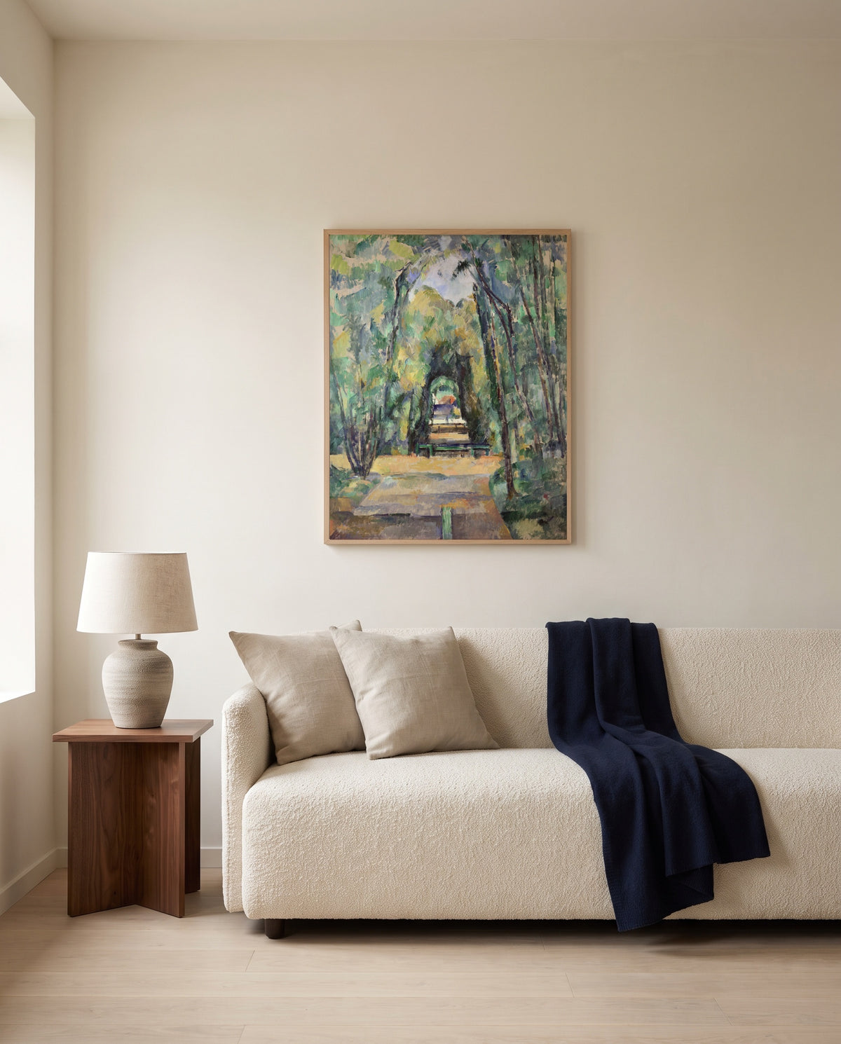 Avenue at Chantilly by Paul Cézanne framed in natural oak above a cream sofa in a warm living room