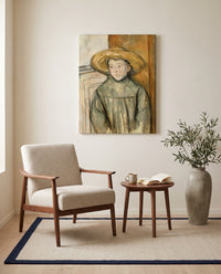 Boy with a Straw Hat by Paul Cézanne as a stretched canvas above a linen lounge chair in a reading corner