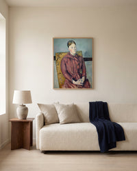 Madame Cézanne by Paul Cézanne framed in natural oak above a cream sofa in a warm living room