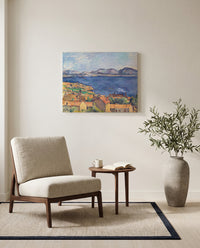 The Bay of Marseille by Paul Cézanne as a stretched canvas above a linen lounge chair in a reading corner