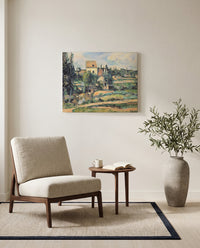 Mill at Pontoise by Paul Cézanne as a stretched canvas above a linen lounge chair in a reading corner