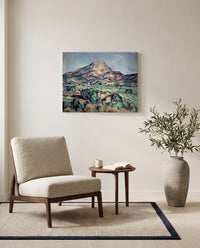 Sainte-Victoire from Bellevue by Paul Cézanne as a stretched canvas above a linen lounge chair in a reading corner
