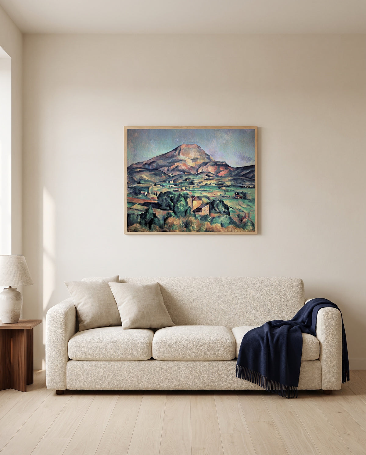 Sainte-Victoire from Bellevue by Paul Cézanne framed in natural oak above a cream sofa in a warm living room