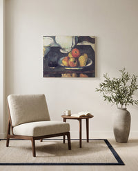 Apples and a Glass of Wine by Paul Cézanne as a stretched canvas above a linen lounge chair in a reading corner