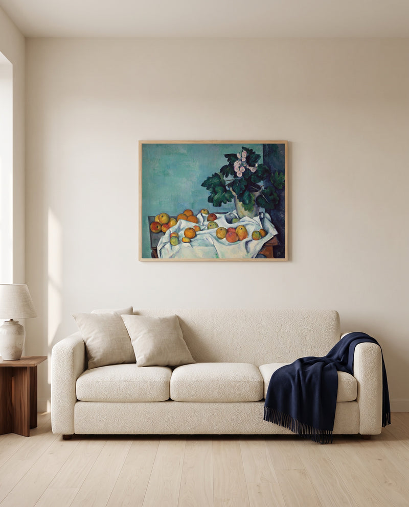 Apples and Primroses by Paul Cézanne framed in natural oak above a cream sofa in a warm living room