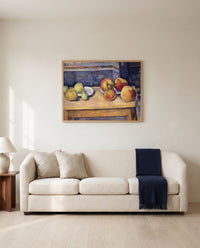 Apples and Pears by Paul Cézanne framed in natural oak above a cream sofa in a warm living room