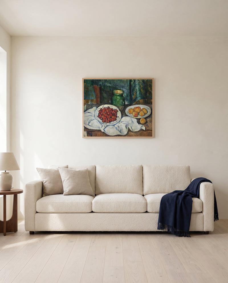 Cherries and Peaches by Paul Cézanne framed in natural oak above a cream sofa in a warm living room
