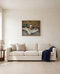 Jar, Cup and Apples by Paul Cézanne framed in natural oak above a cream sofa in a warm living room