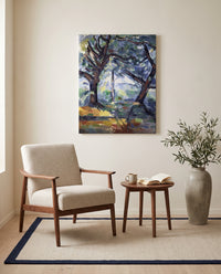 The Big Trees by Paul Cézanne as a stretched canvas above a linen lounge chair in a reading corner
