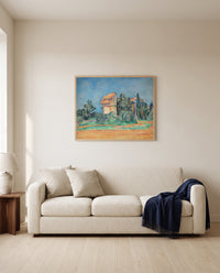 The Pigeon Tower at Bellevue by Paul Cézanne framed in natural oak above a cream sofa in a warm living room