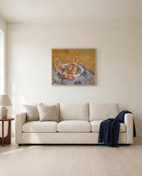 The Plate of Apples by Paul Cézanne framed in natural oak above a cream sofa in a warm living room