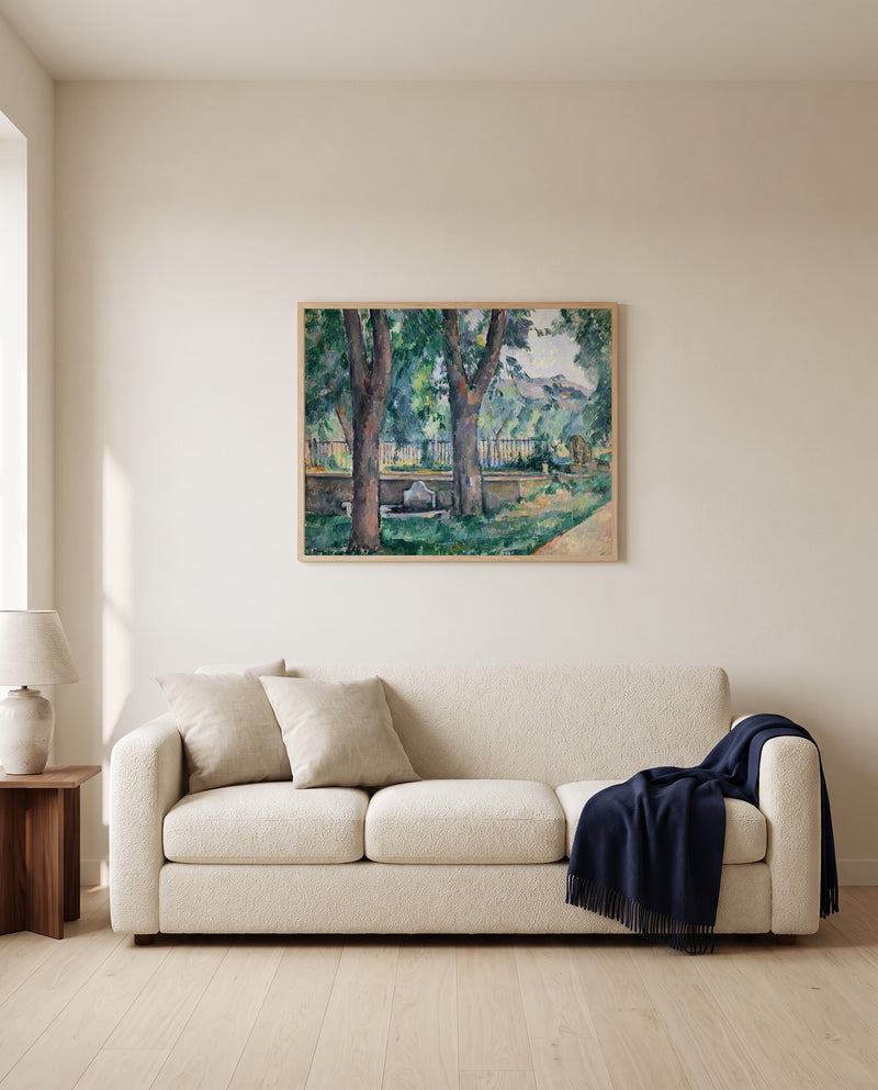 Pool at Jas de Bouffan by Paul Cézanne framed in natural oak above a cream sofa in a warm living room
