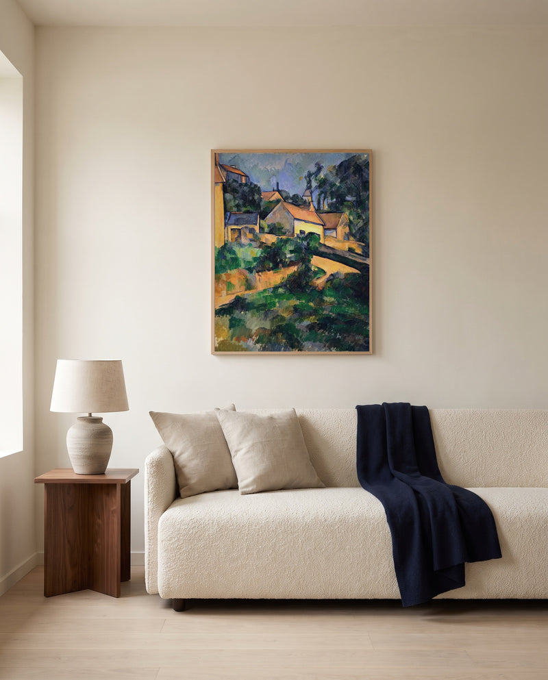 Road at Montgeroult by Paul Cézanne framed in natural oak above a cream sofa in a warm living room