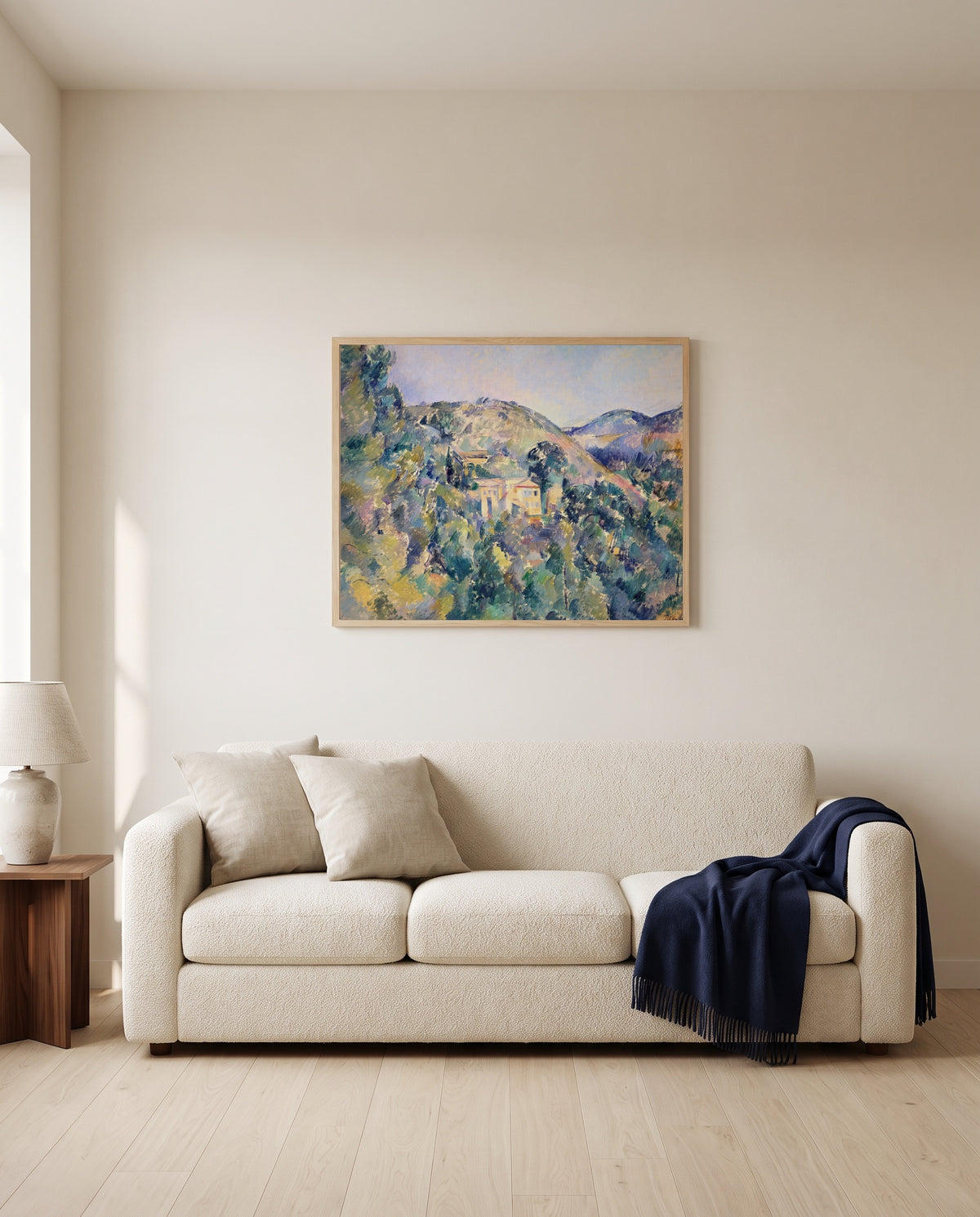 Domaine Saint-Joseph by Paul Cézanne framed in natural oak above a cream sofa in a warm living room