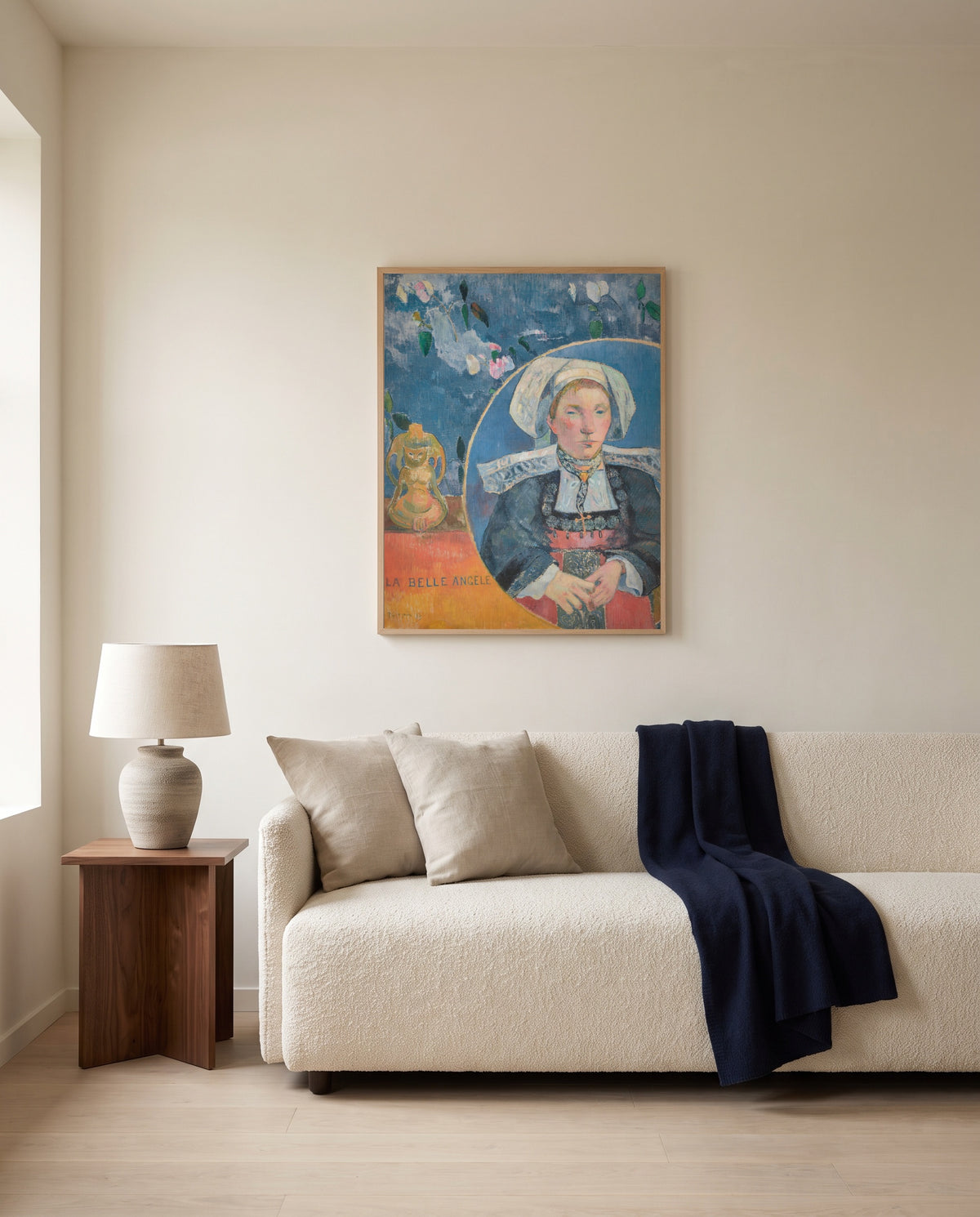 La Belle Angèle by Paul Gauguin framed in natural oak above a cream sofa in a warm living room