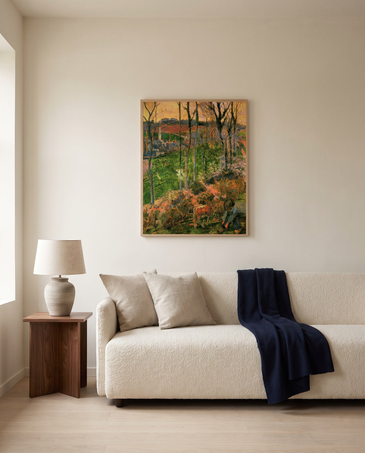Landscape from Pont-Aven by Paul Gauguin framed in natural oak above a cream sofa in a warm living room