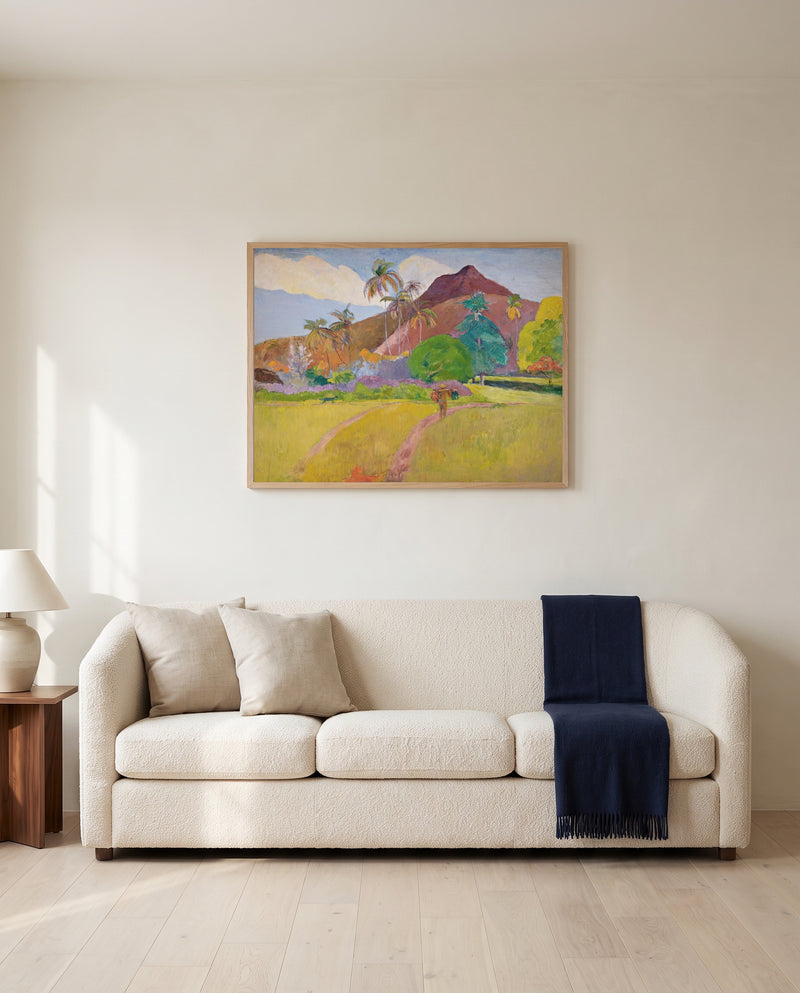 Tahitian Landscape by Paul Gauguin framed in natural oak above a cream sofa in a warm living room