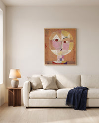 Senecio by Paul Klee framed in natural oak above a cream sofa in a warm living room