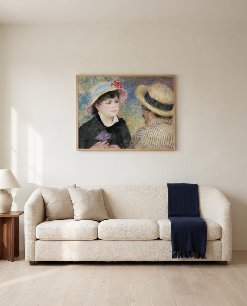 Boating Couple by Pierre-Auguste Renoir framed in natural oak above a cream sofa in a warm living room