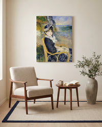 By the Seashore by Pierre-Auguste Renoir as a stretched canvas above a linen lounge chair in a reading corner