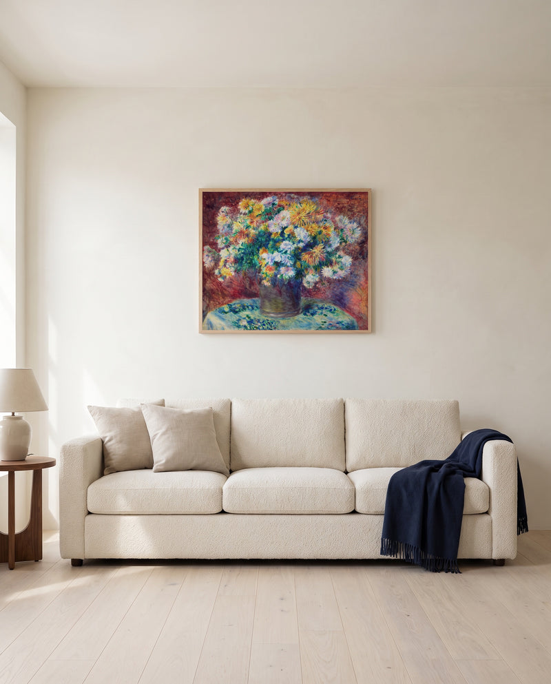 Chrysanthemums by Pierre-Auguste Renoir framed in natural oak above a cream sofa in a warm living room