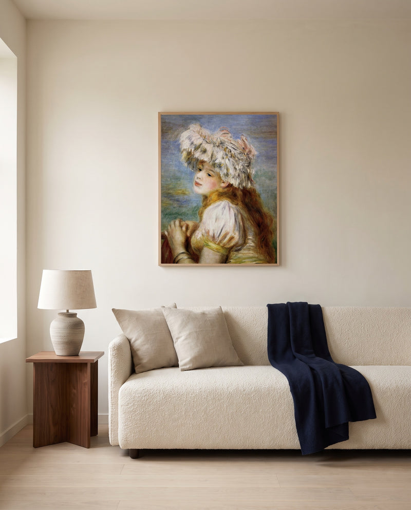 Girl in a Lace Hat by Pierre-Auguste Renoir framed in natural oak above a cream sofa in a warm living room