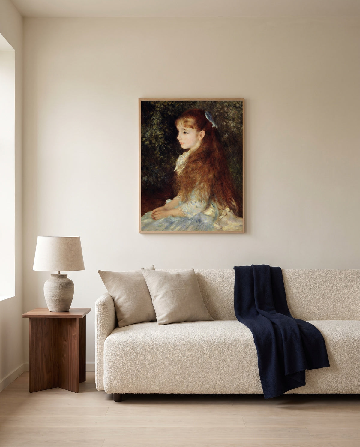 Little Irène by Pierre-Auguste Renoir framed in natural oak above a cream sofa in a warm living room