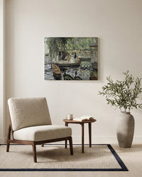 La Grenouillère by Pierre-Auguste Renoir as a stretched canvas above a linen lounge chair in a reading corner