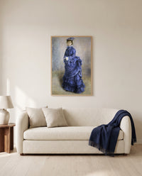 La Parisienne by Pierre-Auguste Renoir framed in natural oak above a cream sofa in a warm living room