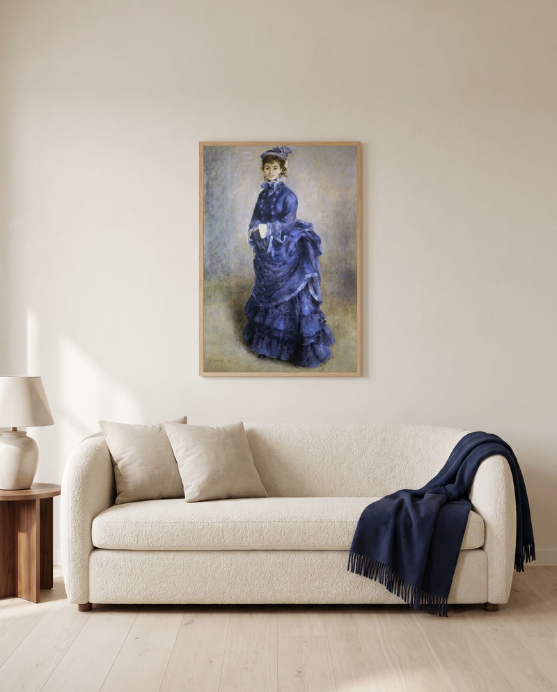 La Parisienne by Pierre-Auguste Renoir framed in natural oak above a cream sofa in a warm living room