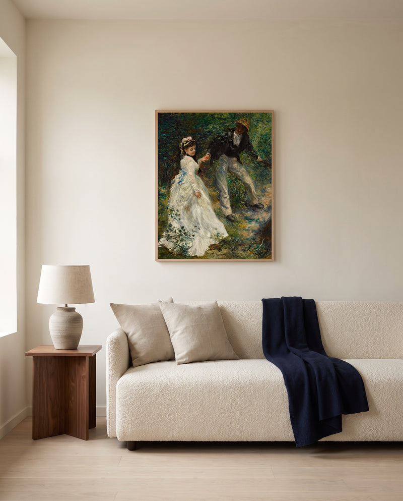 La Promenade by Pierre-Auguste Renoir framed in natural oak above a cream sofa in a warm living room