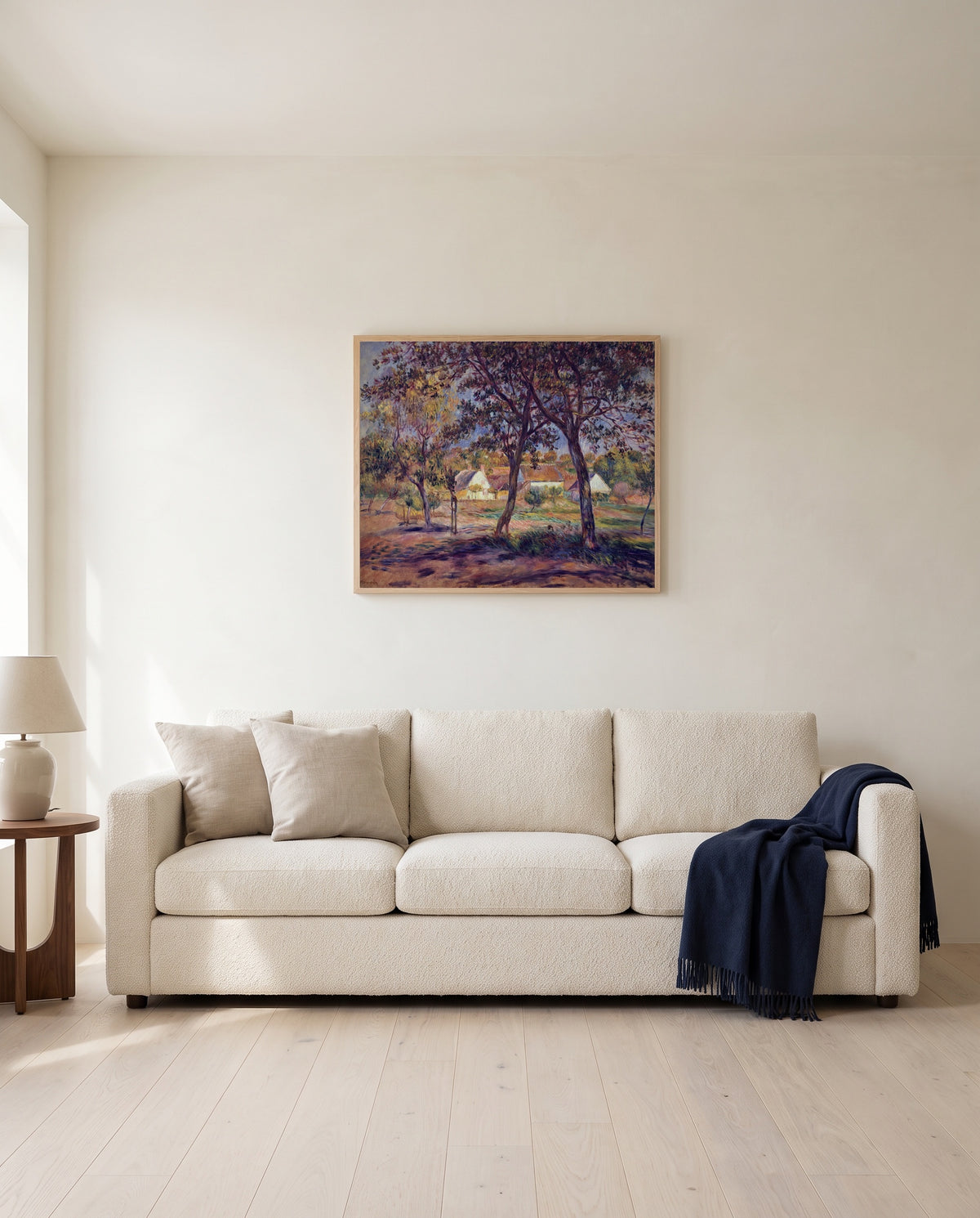 Outskirts of Pont-Aven by Pierre-Auguste Renoir framed in natural oak above a cream sofa in a warm living room