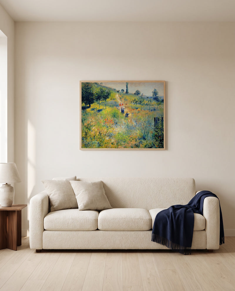 Path through Tall Grass by Pierre-Auguste Renoir framed in natural oak above a cream sofa in a warm living room