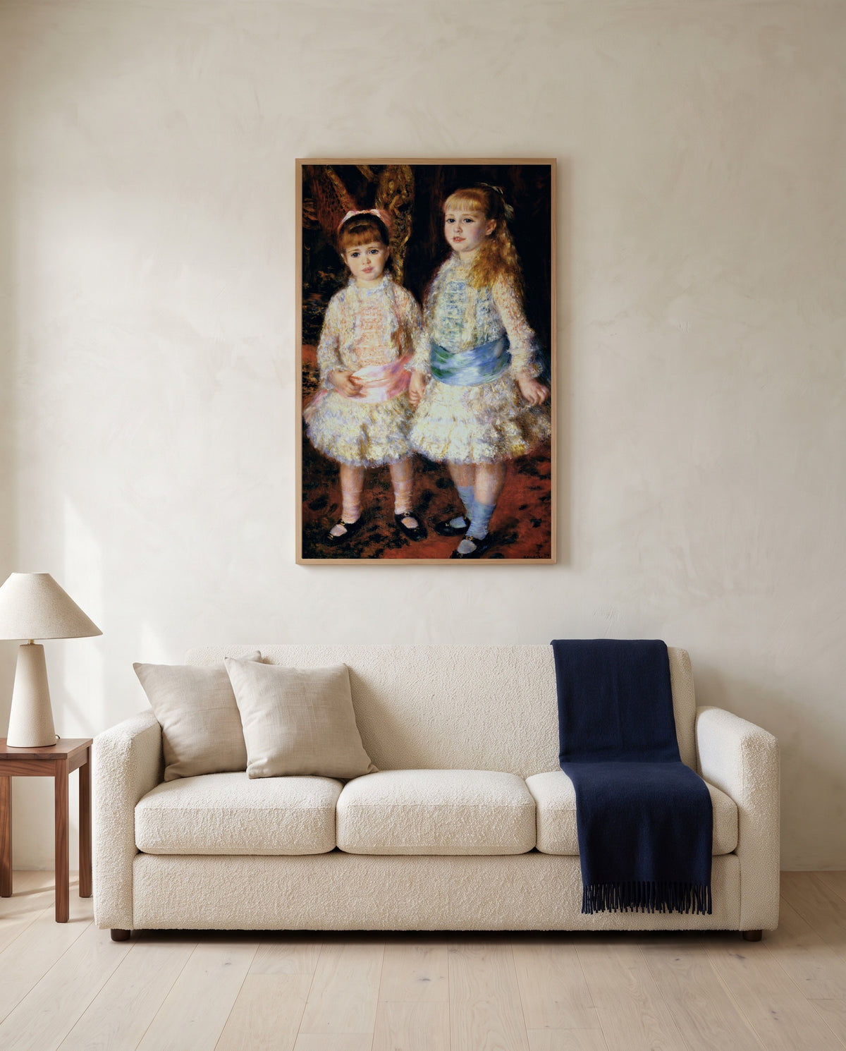 Pink and Blue by Pierre-Auguste Renoir framed in natural oak above a cream sofa in a warm living room