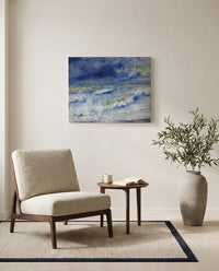Seascape by Pierre-Auguste Renoir as a stretched canvas above a linen lounge chair in a reading corner