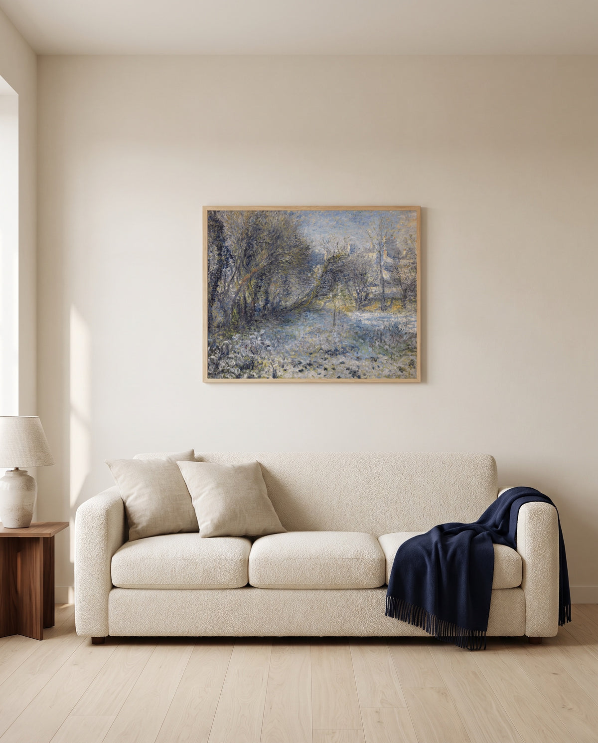 Snowy Landscape by Pierre-Auguste Renoir framed in natural oak above a cream sofa in a warm living room