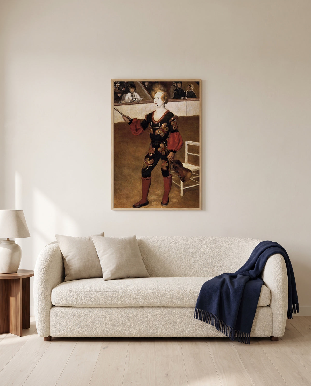 The Clown by Pierre-Auguste Renoir framed in natural oak above a cream sofa in a warm living room