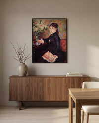The Cup of Chocolate by Pierre-Auguste Renoir in a black frame above a walnut sideboard in a dining room