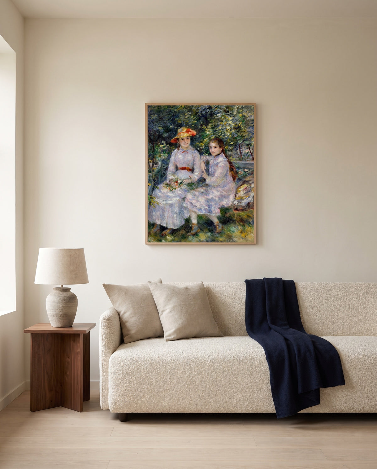 Durand-Ruel Daughters by Pierre-Auguste Renoir framed in natural oak above a cream sofa in a warm living room