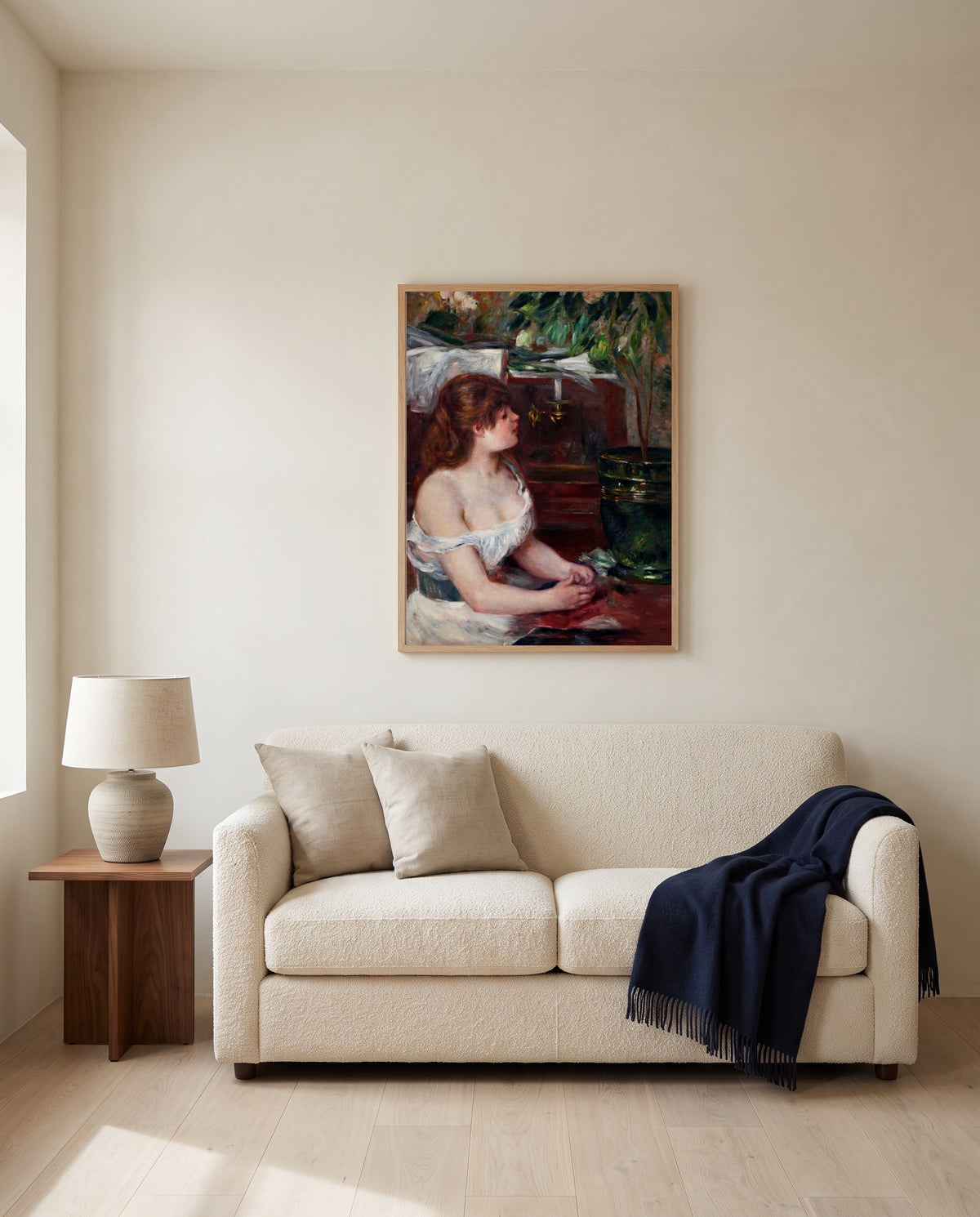 The Green Jardinière by Pierre-Auguste Renoir framed in natural oak above a cream sofa in a warm living room