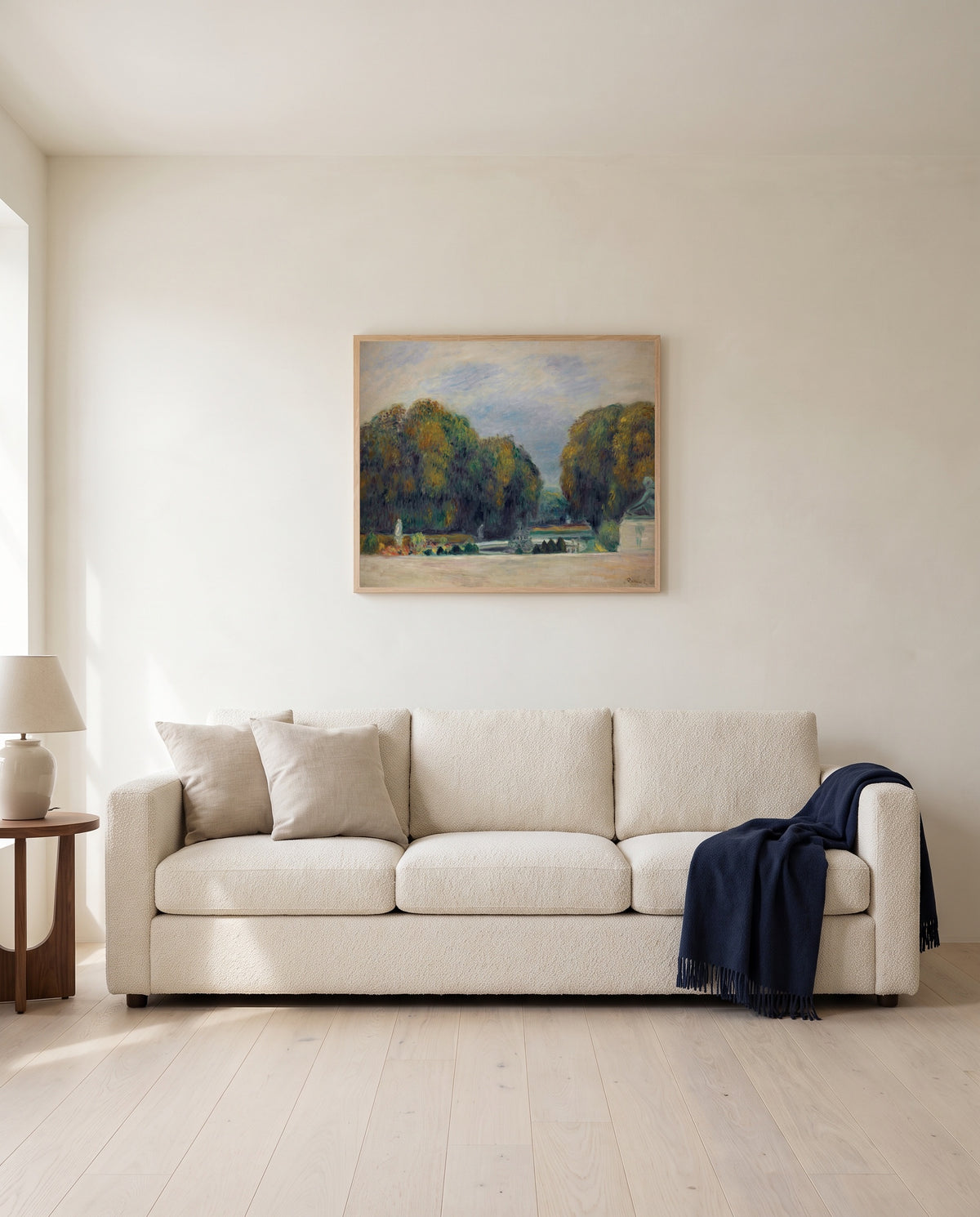 Versailles by Pierre-Auguste Renoir framed in natural oak above a cream sofa in a warm living room