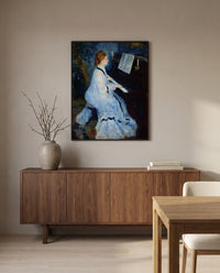Woman at the Piano by Pierre-Auguste Renoir in a black frame above a walnut sideboard in a dining room