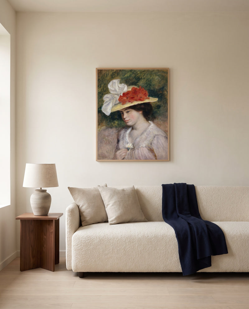 Woman in a Flowered Hat by Pierre-Auguste Renoir framed in natural oak above a cream sofa in a warm living room