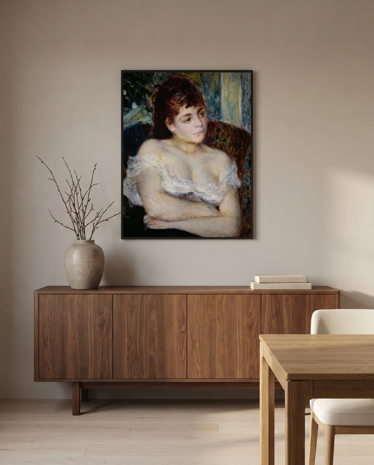 Woman in an Armchair by Pierre-Auguste Renoir in a black frame above a walnut sideboard in a dining room