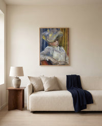 Woman with a Hat by Pierre-Auguste Renoir framed in natural oak above a cream sofa in a warm living room