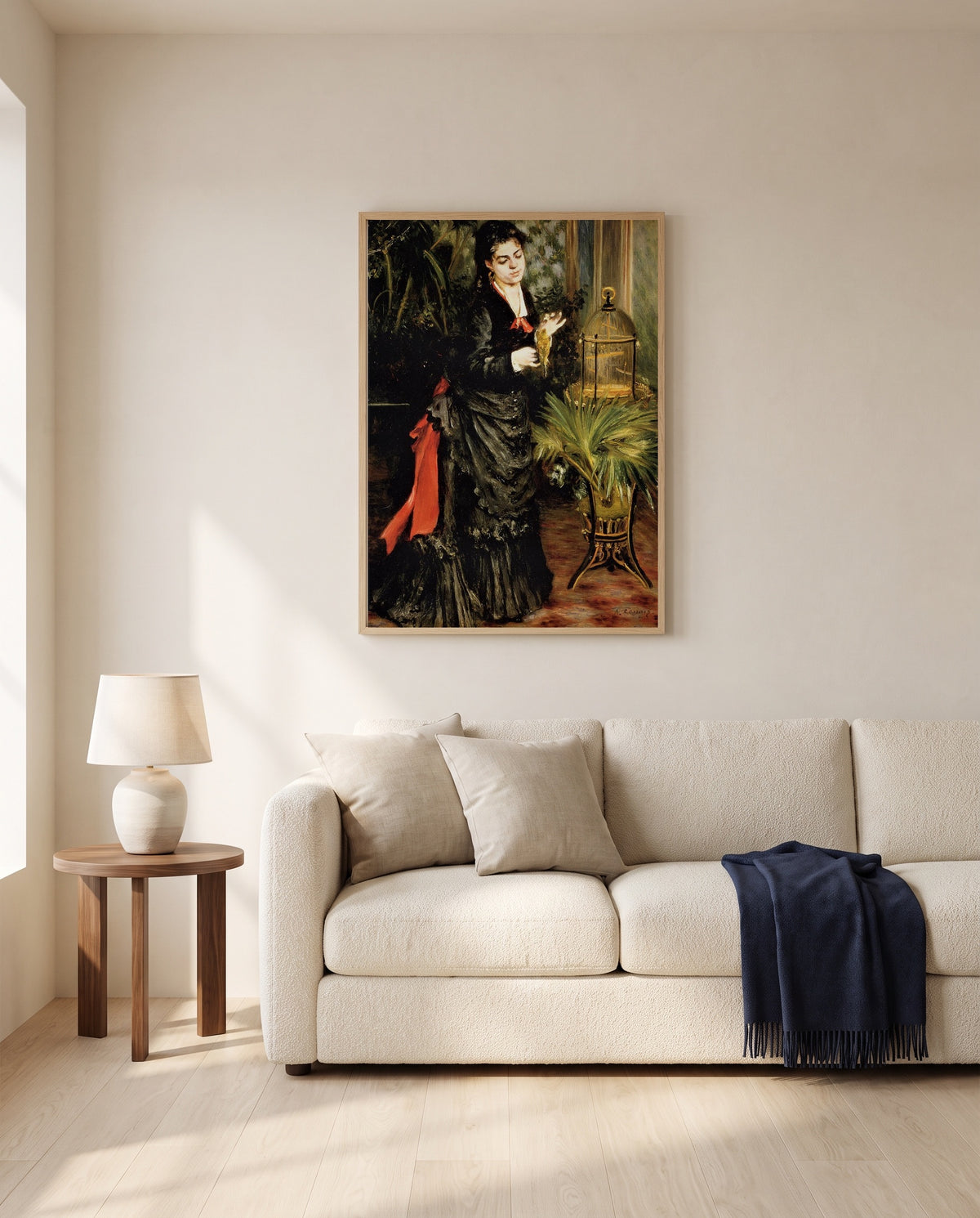 Woman with a Parrot by Pierre-Auguste Renoir framed in natural oak above a cream sofa in a warm living room