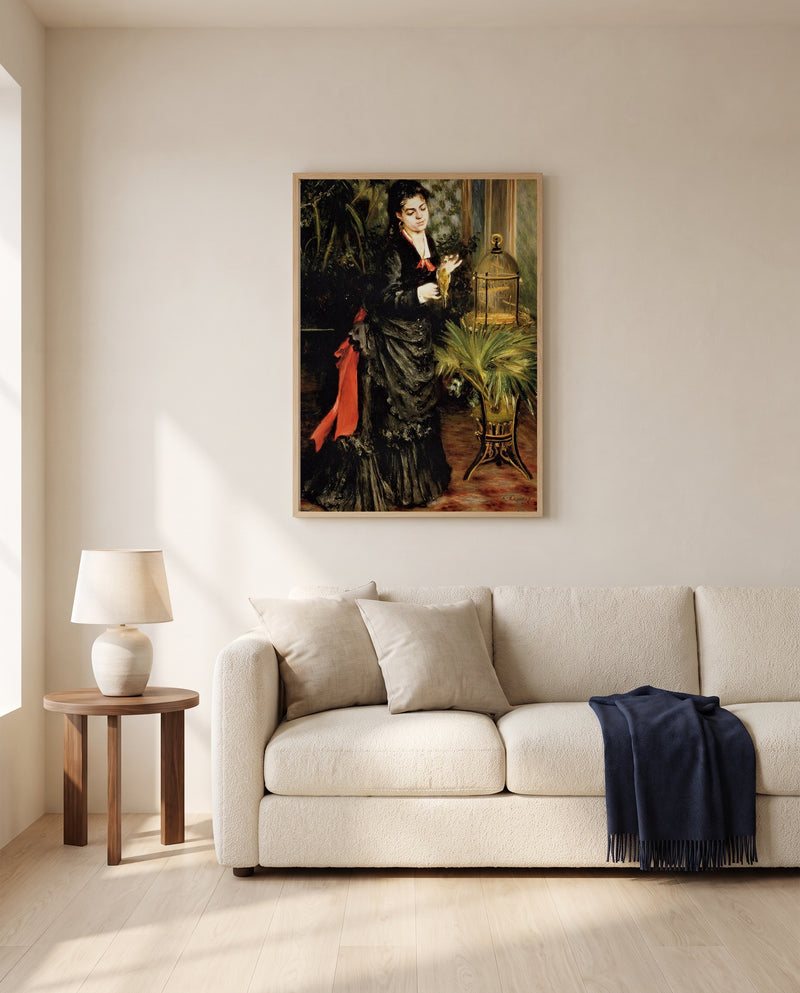 Woman with a Parrot by Pierre-Auguste Renoir framed in natural oak above a cream sofa in a warm living room
