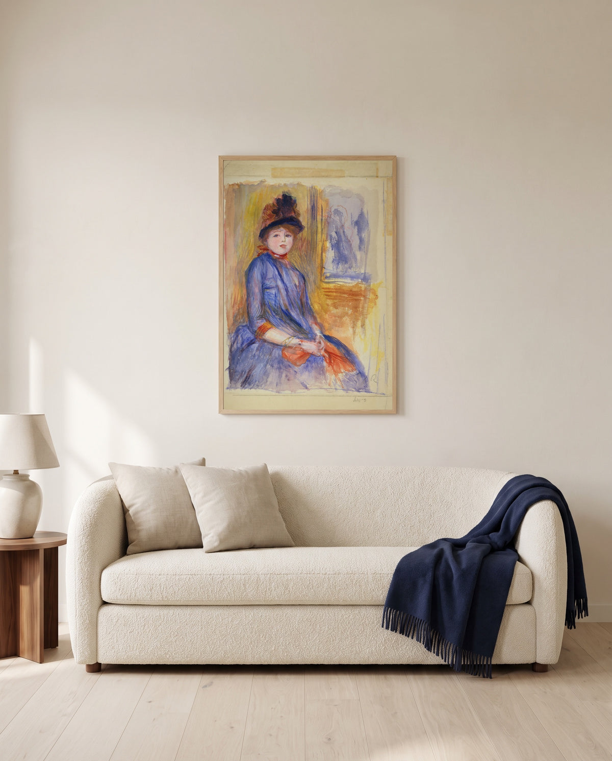 Young Girl in a Blue Dress by Pierre-Auguste Renoir framed in natural oak above a cream sofa in a warm living room