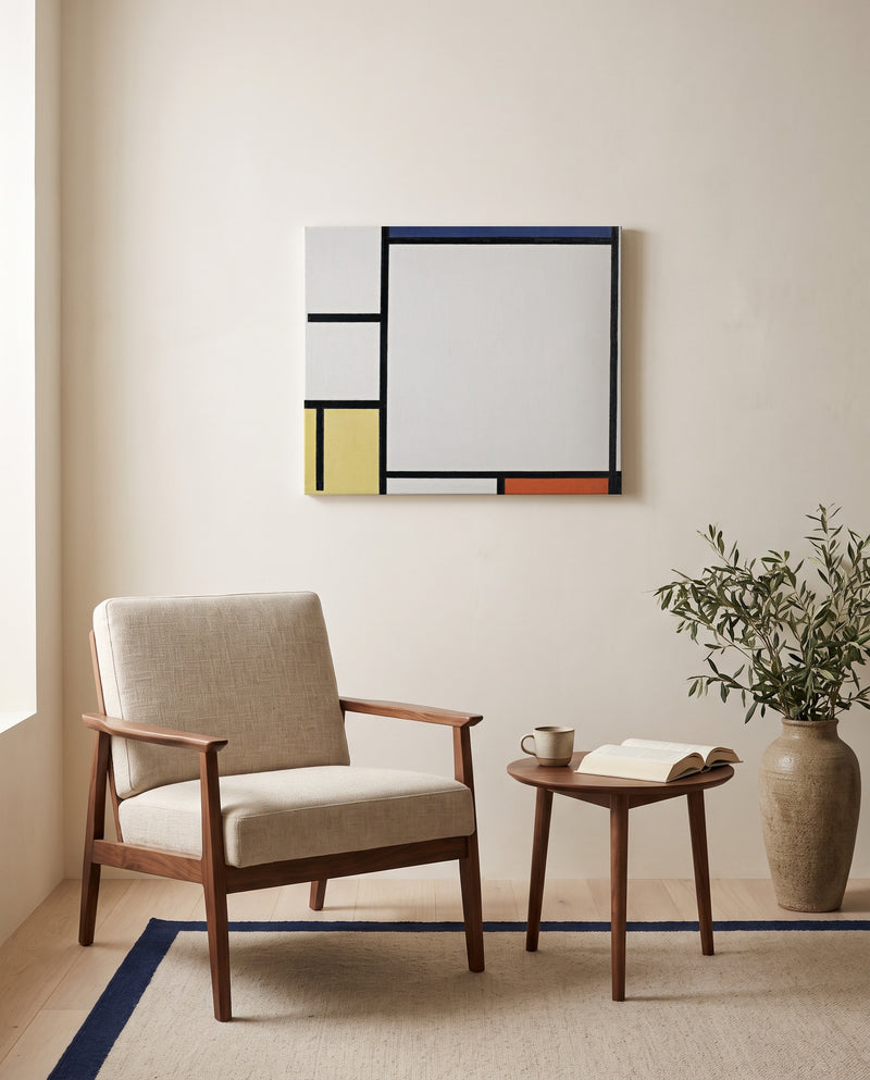 Blue, Red, Yellow and Black by Piet Mondrian as a stretched canvas above a linen lounge chair in a reading corner