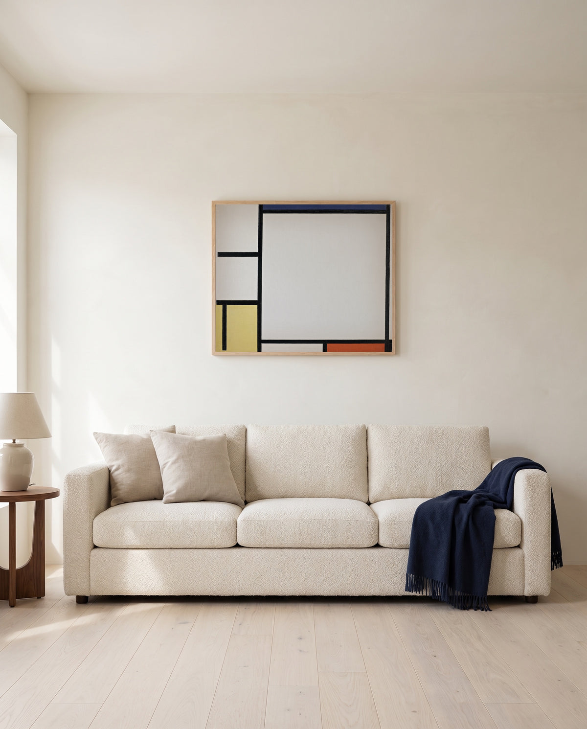 Blue, Red, Yellow and Black by Piet Mondrian framed in natural oak above a cream sofa in a warm living room